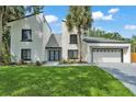 Contemporary two-story home with a well-manicured lawn, palm trees and modern architectural design at 4520 Pine Hollow Dr, Tampa, FL 33624