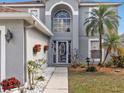 Home's entrance with a decorative front door, complemented by a manicured garden and stone pathway at 5337 Treig Ln, Wesley Chapel, FL 33545