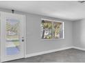 Renovated living room featuring a door to the outside and a view through a window at 5440 Quist Dr, Port Richey, FL 34668