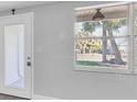 Bright living room with a new window, view of the front yard, and a door leading to a patio at 5440 Quist Dr, Port Richey, FL 34668