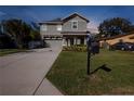 Attractive two-story home with a well-kept front yard, a long driveway, and an attached garage at 715 W Woodlawn Ave, Tampa, FL 33603