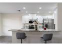 Eat-in kitchen featuring stainless steel appliances, white cabinetry, and elegant countertops with bar stool seating at 10424 Gifford Dr, Spring Hill, FL 34608