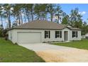 Charming single-story home features a well-maintained lawn, neutral paint, a two-car garage, and classic black shutters at 12341 Filbert Rd, Brooksville, FL 34614