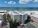 Aerial view of a beachfront condo with a parking lot, beach access, and stunning water views at 12924 Gulf Blvd # 503, Madeira Beach, FL 33708