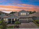 Striking exterior of a two-story home, showcasing a well-maintained lawn, brick driveway, and spacious three-car garage at 13069 Paddock Wood Pl, Riverview, FL 33579