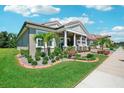 Eye-catching single-Gathering home featuring a lush lawn, landscaped garden beds, and a welcoming front porch at 13069 Paddock Wood Pl, Riverview, FL 33579