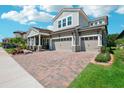 Beautiful home showcasing a well-kept lawn, brick driveway, with a convenient two-car garage at 13069 Paddock Wood Pl, Riverview, FL 33579