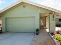 The home features a one car garage and a covered walkway to the front door at 1363 Overlea Dr, Dunedin, FL 34698