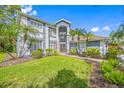 Beautiful two-story home with a well-manicured lawn, tropical plants, and a welcoming facade at 15702 Muirfield Dr, Odessa, FL 33556