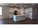 Bright kitchen with white cabinets, stainless steel appliances, and a center island with a sink at 17045 James Trl, Parrish, FL 34219