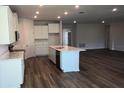 Open kitchen layout with a central island, stainless steel sink, and abundant cabinetry at 17126 James Trl, Parrish, FL 34219
