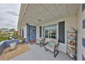 Charming front porch with seating and decorative touches, showcasing the home's inviting exterior and curb appeal at 1805 Columbine Pl, Sun City Center, FL 33573