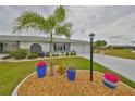 Beautiful landscaping complements this well-maintained house with an attached garage and a dark-colored front door at 1805 Columbine Pl, Sun City Center, FL 33573