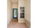 Covered entry porch with brick flooring, a blue front door with a window, and an additional window at 18186 Sandy Pointe Dr, Tampa, FL 33647
