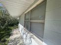 Close-up of a window and the exterior wall with white siding, showcasing the house's architecture at 1924 45Th Street E Ct, Bradenton, FL 34208