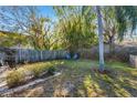 A fenced backyard with a grassy area and mature trees offers a private outdoor space at 200 S Bayshore Blvd, Clearwater, FL 33759