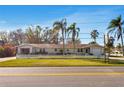Charming single-story home surrounded by lush greenery, palm trees and a picket fence at 200 S Bayshore Blvd, Clearwater, FL 33759