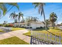 Charming single-story home featuring a white picket fence and mature palm trees at 200 S Bayshore Blvd, Clearwater, FL 33759