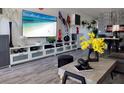 This living room has hardwood floors, white shelves, decor, modern art and a large flat screen television at 2256 Spanish Dr # 42, Clearwater, FL 33763