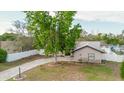 Spacious home featuring a long driveway, fenced yard, and mature tree at 2427 Comerwood Dr, Spring Hill, FL 34609