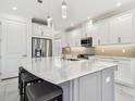 A gourmet kitchen featuring a large center island with seating, white cabinets, and stainless steel appliances at 4228 Isonzo Way, Wesley Chapel, FL 33543