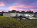 Exterior of a well-maintained home featuring a manicured lawn and clean architectural lines at dusk at 5433 Chestnut Ridge Rd, Dade City, FL 33523