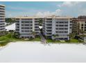 Exterior view of beachside condo buildings with direct beach access and manicured lawn at 6310 Midnight Pass Rd # 204N, Sarasota, FL 34242