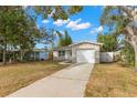 Inviting single-story home featuring a well-manicured lawn, long driveway, and attached single-car garage under a bright sky at 673 Folsom S St, St Petersburg, FL 33707