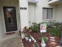 Front of house featuring a welcoming entrance with a gnome and a 'home sweet home' sign, complemented by lush greenery at 8055 Picketts Ct # 1, Weeki Wachee, FL 34613