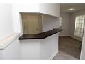 Kitchen pass-through with dark countertops overlooks living area at 8659 Fancy Finch Dr # 202, Tampa, FL 33614