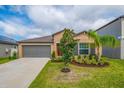 Single-Gathering home featuring a two-car garage, landscaped yard and neutral tones at 9313 Channing Hill Dr, Ruskin, FL 33573