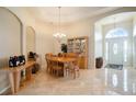 Bright dining room with a tray ceiling, tiled floors, and an ornate chandelier overhead at 13712 Trinity Leaf Pl, Riverview, FL 33579