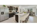 Modern kitchen featuring stainless steel appliances, an island with seating and dark wood cabinets at 17048 James Trl, Parrish, FL 34219