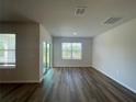 Bright living room featuring sleek wood-look flooring and natural light at 17048 James Trl, Parrish, FL 34219