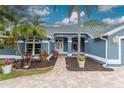 Inviting home exterior with a brick pathway leading to the front door and lush landscaping at 17508 Isbell Ln, Odessa, FL 33556