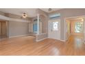 Open living room with wood floors, large windows, and natural light pouring through at 17508 Isbell Ln, Odessa, FL 33556