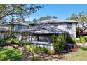 Well-maintained two-story exterior with a screened in porch and lush landscaping at 2904 Lichen Ln # A, Clearwater, FL 33760