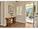 Bright foyer featuring hardwood floors, stylish console table, and a view of the beautifully landscaped front yard at 536 Ontario Ave, Crystal Beach, FL 34681