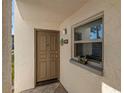 Inviting entryway with tiled floor, modern door, stylish number plaque, and decorative window planter at 7701 Starkey Rd # 737, Seminole, FL 33777