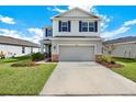 Charming two-story home with a two car garage, blue shutters and well manicured lawn on a sunny day at 10432 High Noon Trl, Parrish, FL 34219