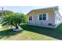 Beautiful home exterior with lush green lawn, palm tree accent, and neutral-colored siding at 36838 Tara Ave, Zephyrhills, FL 33542