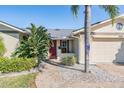 Close up of the front of a home with a red front door and well manicured landscaping at 4383 Biscayne Dr, Hernando Beach, FL 34607