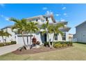 Attractive two-story home boasting a two-car garage, verdant lawn, and lush palm trees at 5318 Wishing Arch Dr, Apollo Beach, FL 33572