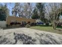Exterior of home featuring a long driveway, mature trees, and updated landscaping at 5704 Half Moon Lake Rd, Tampa, FL 33625