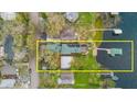 Aerial view of the lakefront property highlighting the house, expansive deck and large wooden dock at 680 George S St, Tarpon Springs, FL 34688