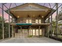 Spacious two-story screened outdoor area with stone accents, balcony, and outdoor bar at 680 George S St, Tarpon Springs, FL 34688