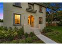 Close-up of front exterior featuring an arched entrance, gray trim, and professionally landscaped yard with vibrant plants at 7125 6Th N Ave, St Petersburg, FL 33710