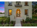 Detailed exterior shot showcasing the front entrance, windows with gray trim, and lush landscaping surrounding the home at 7125 6Th N Ave, St Petersburg, FL 33710