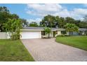 Single-story home with a brick driveway, a two-car garage and a well-maintained lawn at 8275 32Nd N Ave, St Petersburg, FL 33710