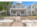 Charming two-story home featuring a welcoming front porch with brick walkway and nicely manicured landscape at 868 44Th N Ave, St Petersburg, FL 33703